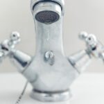 Rubinetto del bagno con calcare, affiancato da un ingrediente da cucina per la pulizia efficace.