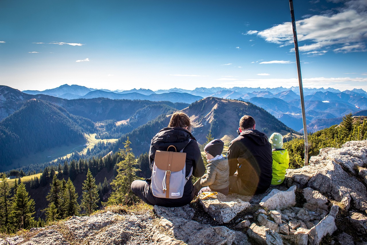 Famiglia che cammina su un sentiero panoramico tra alberi e natura.